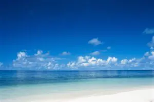A beach with white sand and blue water