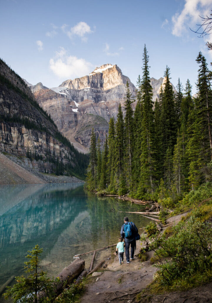 A man and woman walking along side of a lake.